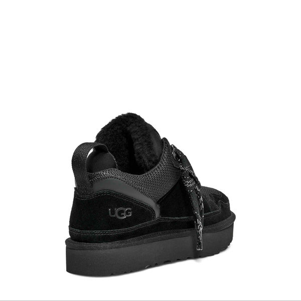 Black sneaker with 'UGG' logo on a white background