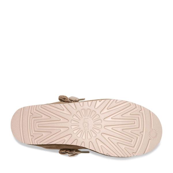 Beige sandal with a textured sole on a white background