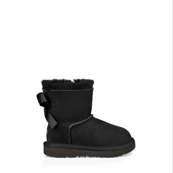 Black suede boot with a bow on a white background