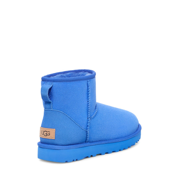 Blue ankle-height boot with a rounded toe and a flat sole on a white background.