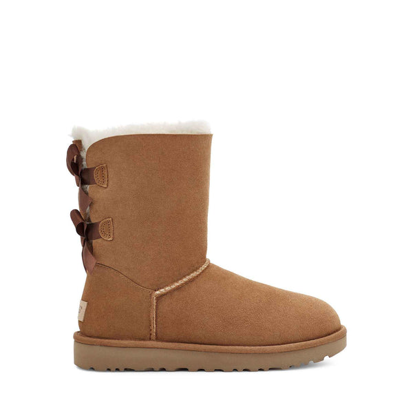 Tan suede boot with three brown buttons on a white background