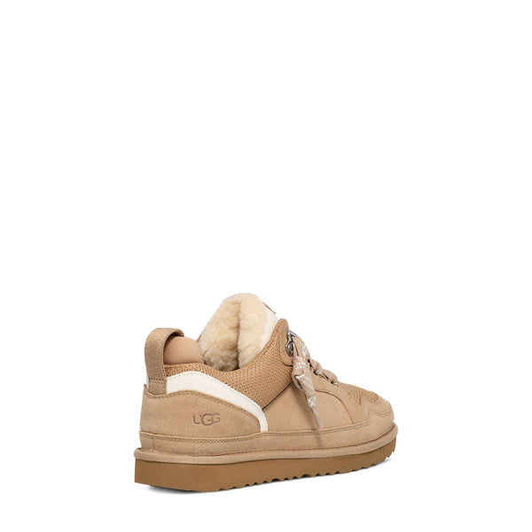 Tan sneaker with white sole on a white background