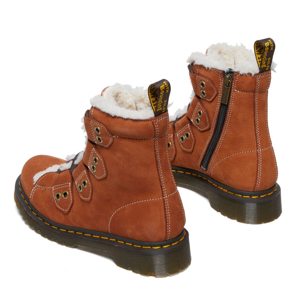 A pair of brown winter boots with fluffy white lining and yellow stitching.