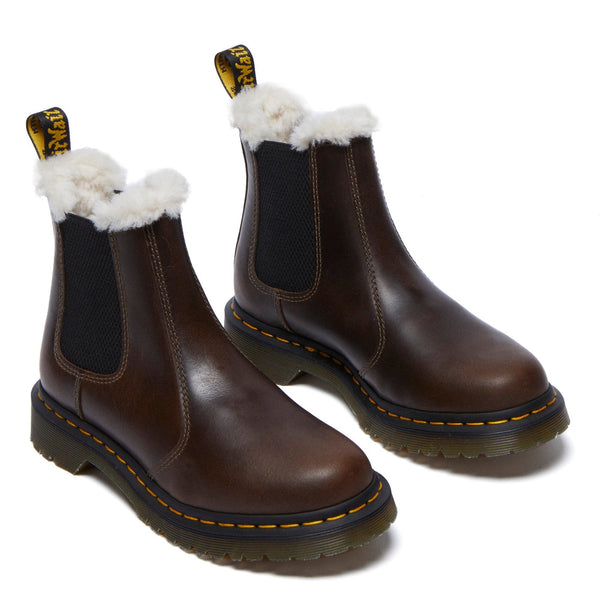 A pair of brown leather boots with fur lining and yellow stitching on a white background.